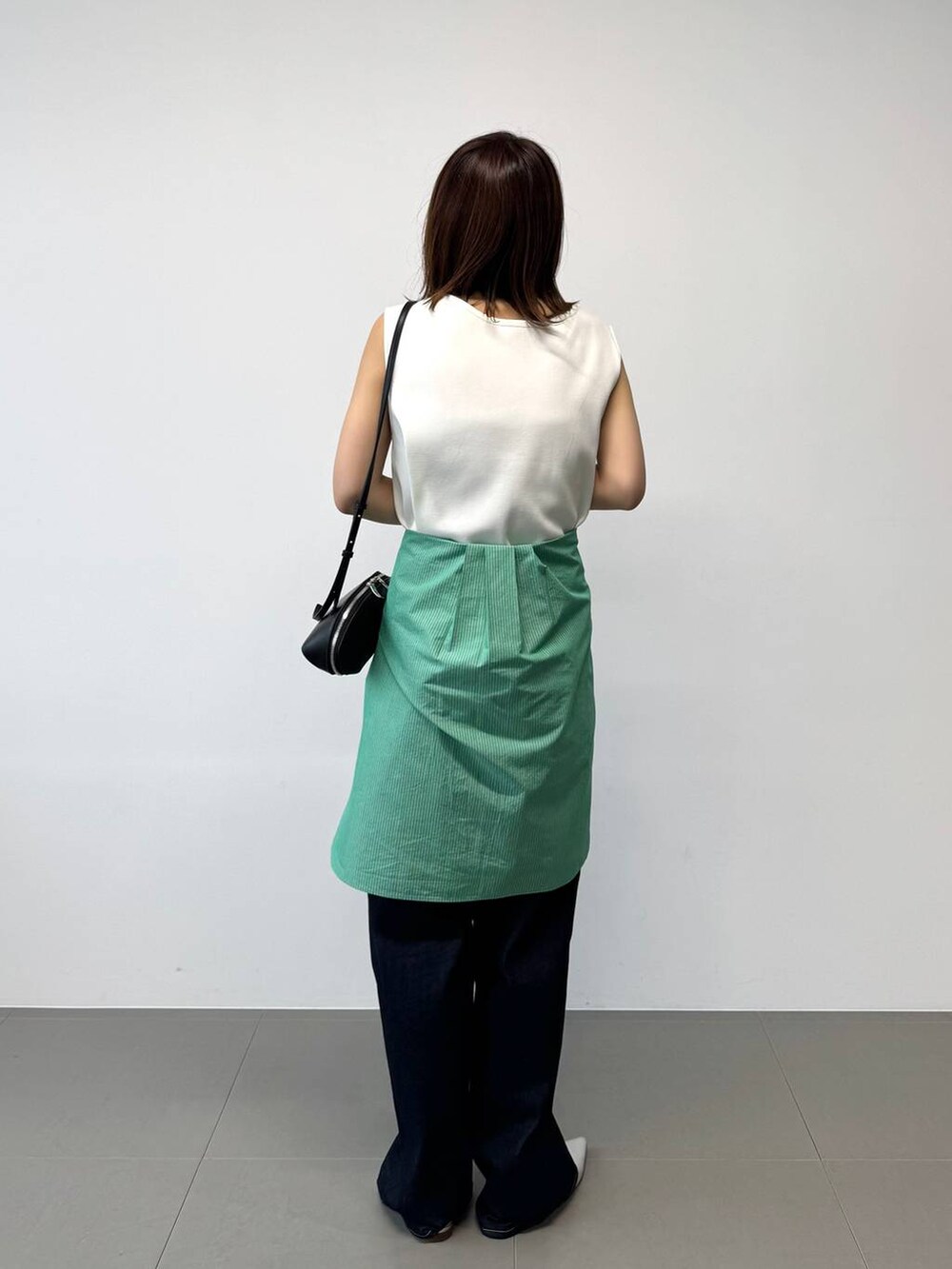 シルバー系のパンプス、グリーン系のシャツ/ブラウス、ホワイト系のTシャツ/カットソーを着用したレディースの夏コーディネートの6枚目の写真