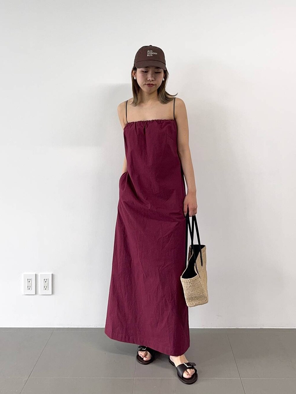 ベージュ系のかごバッグ、レッド系のワンピース、ブラウン系のキャップを着用したレディースの春コーディネートの8枚目の写真