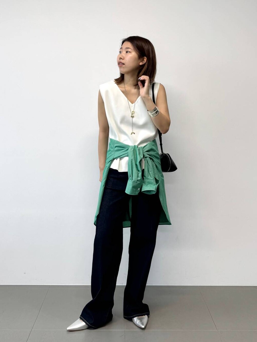 シルバー系のパンプス、グリーン系のシャツ/ブラウス、ホワイト系のTシャツ/カットソーを着用したレディースの夏コーディネートの2枚目の写真