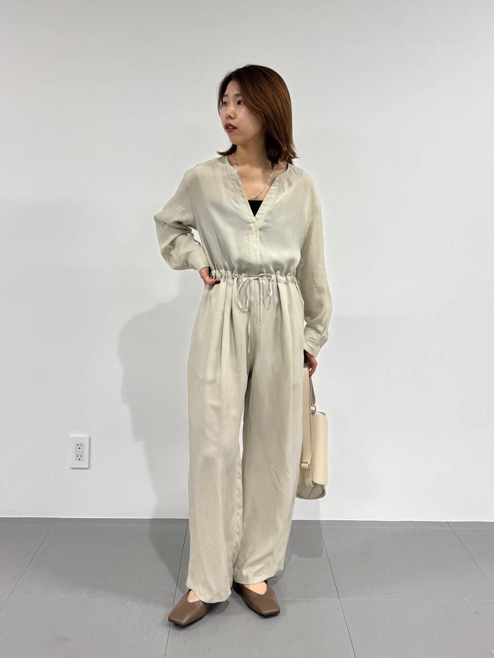 ホワイト系のショルダーバッグ、ブラック系のキャミソール、ベージュ系のつなぎ/オールインワンを着用したレディースの春コーディネートの3枚目の写真