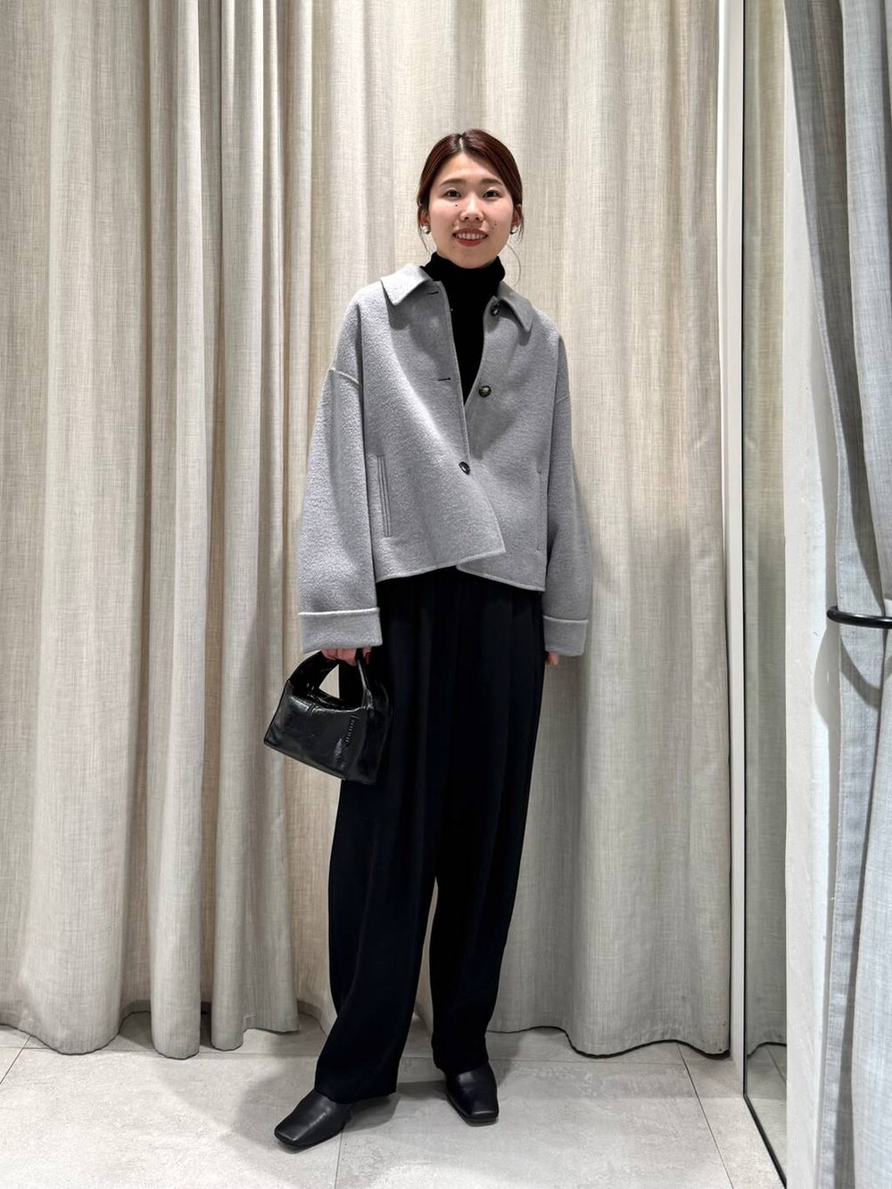 ブラック系のその他パンツ、ブラック系のニット/セーター、グレー系のその他アウターを着用したレディースの冬コーディネートの3枚目の写真