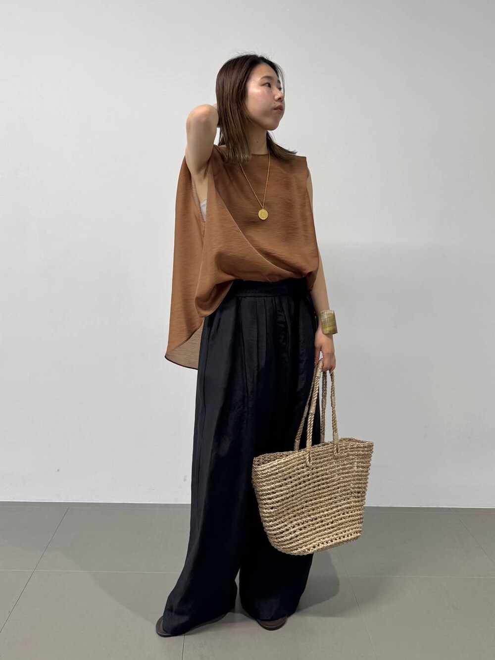 ベージュ系のかごバッグ、ブラウン系のシャツ/ブラウス、ブラック系のその他パンツを着用したレディースの夏コーディネートの2枚目の写真