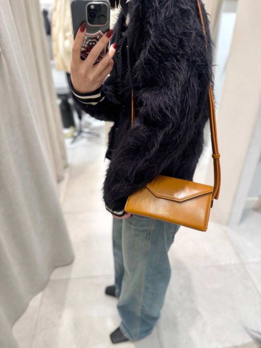 ブラック系のTシャツ/カットソー、ブルー系のカーディガン/ボレロ、ブルー系のデニムパンツを着用したレディースの冬コーディネートの8枚目の写真