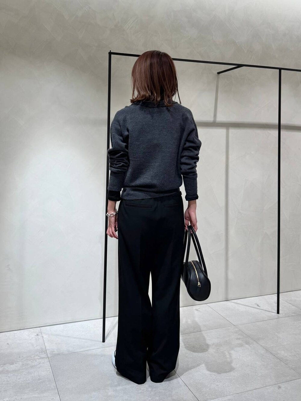 ブラック系のスニーカー、ブラック系のTシャツ/カットソー、グレー系のニット/セーターを着用したレディースの冬コーディネートの6枚目の写真