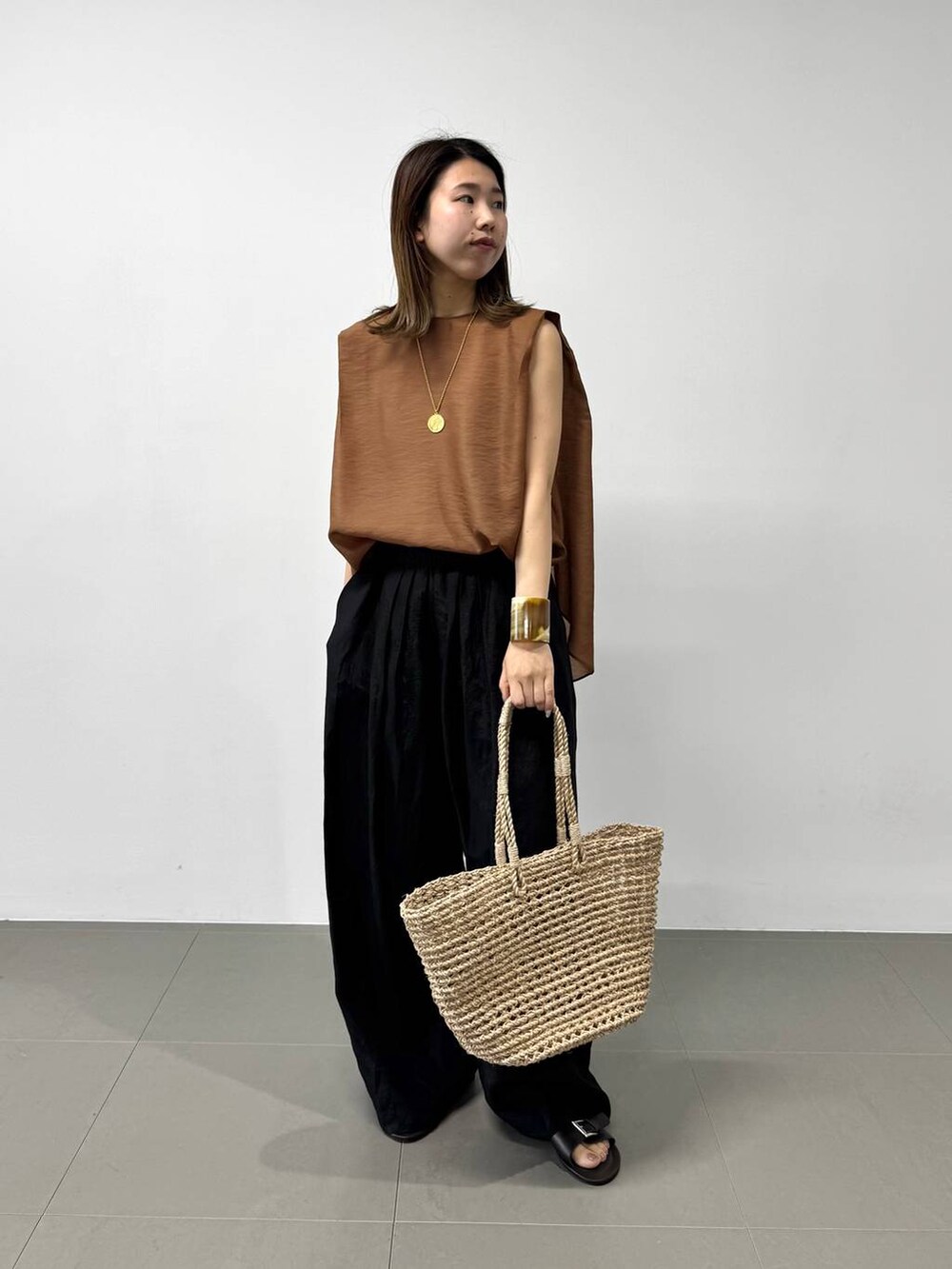 ベージュ系のかごバッグ、ブラウン系のシャツ/ブラウス、ブラック系のその他パンツを着用したレディースの夏コーディネートの6枚目の写真