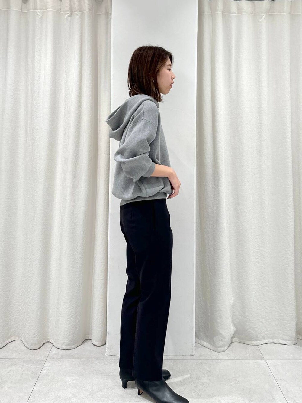 レッド系のショルダーバッグ、ブラック系のスラックス、グレー系のパーカーを着用したレディースの秋コーディネートの5枚目の写真