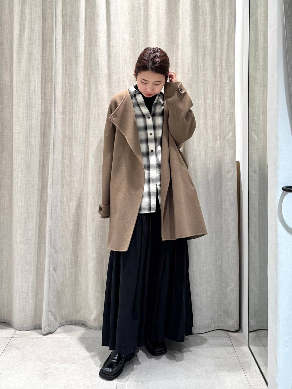 ブラック系のニット/セーター、ブラック系のシャツ/ブラウス、グリーン系のピーコートを着用したレディースの冬コーディネートの2枚目の写真