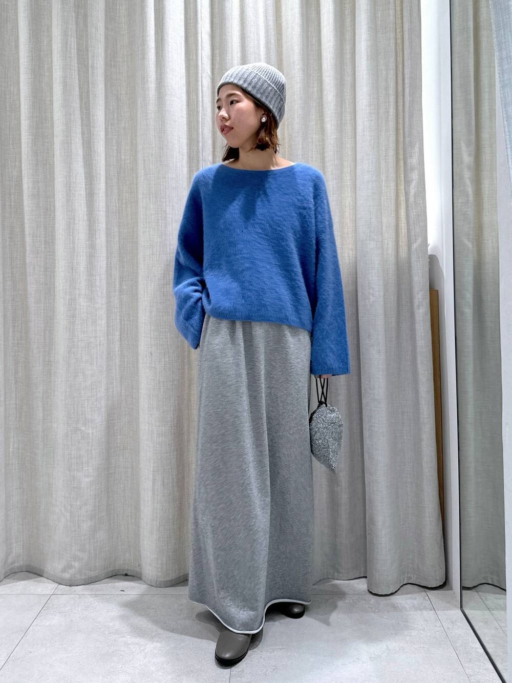 ブルー系のデニムジャケット、ブルー系のニット/セーター、シルバー系のショルダーバッグを着用したレディースの秋コーディネートの7枚目の写真