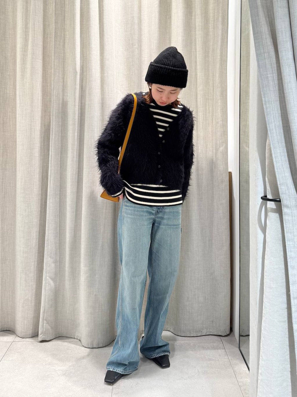 ブラック系のTシャツ/カットソー、ブルー系のカーディガン/ボレロ、ブルー系のデニムパンツを着用したレディースの冬コーディネートの3枚目の写真