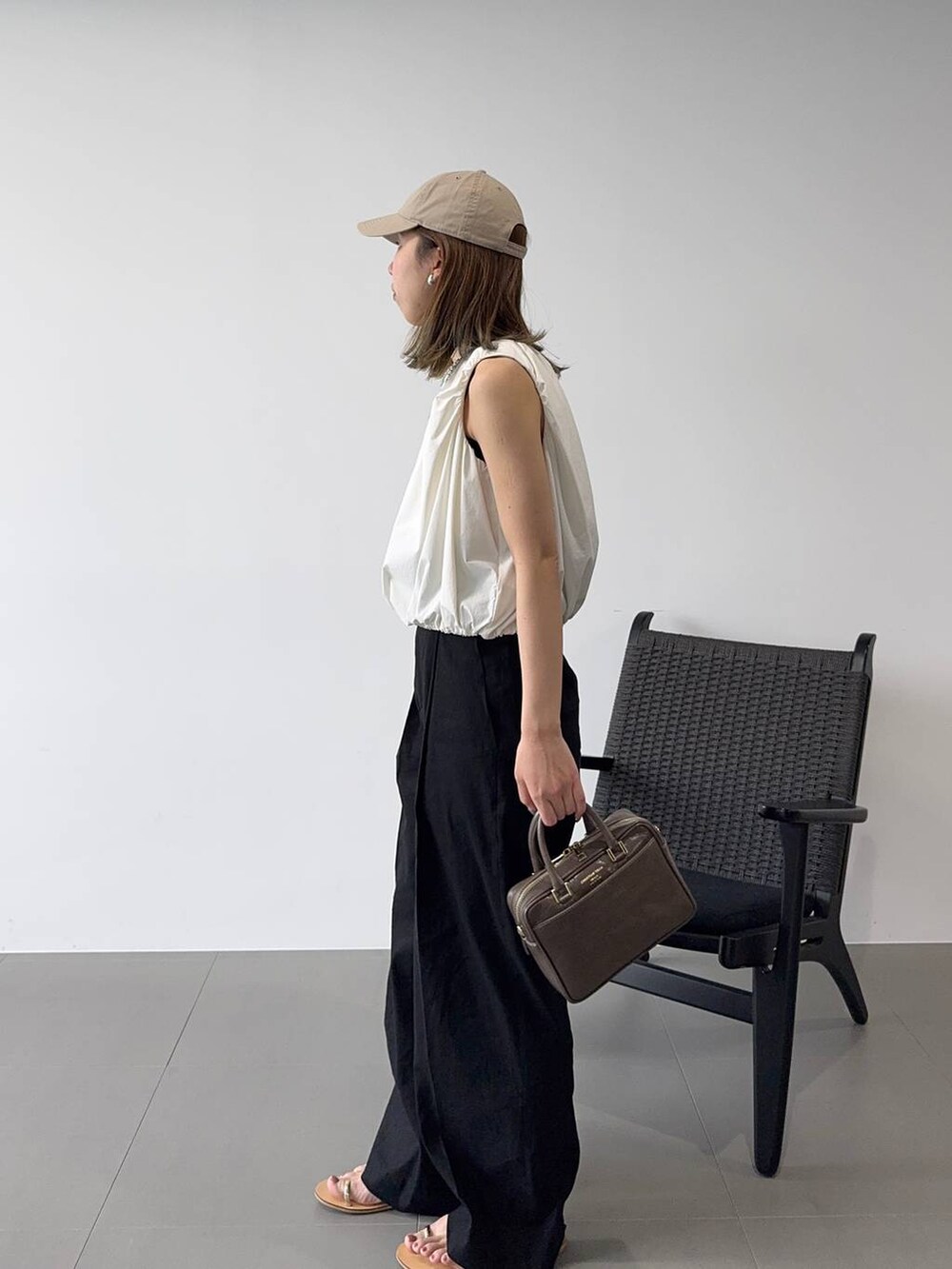 ブラック系のその他パンツ、ホワイト系のシャツ/ブラウス、ベージュ系のサンダルを着用したレディースの春コーディネートの2枚目の写真