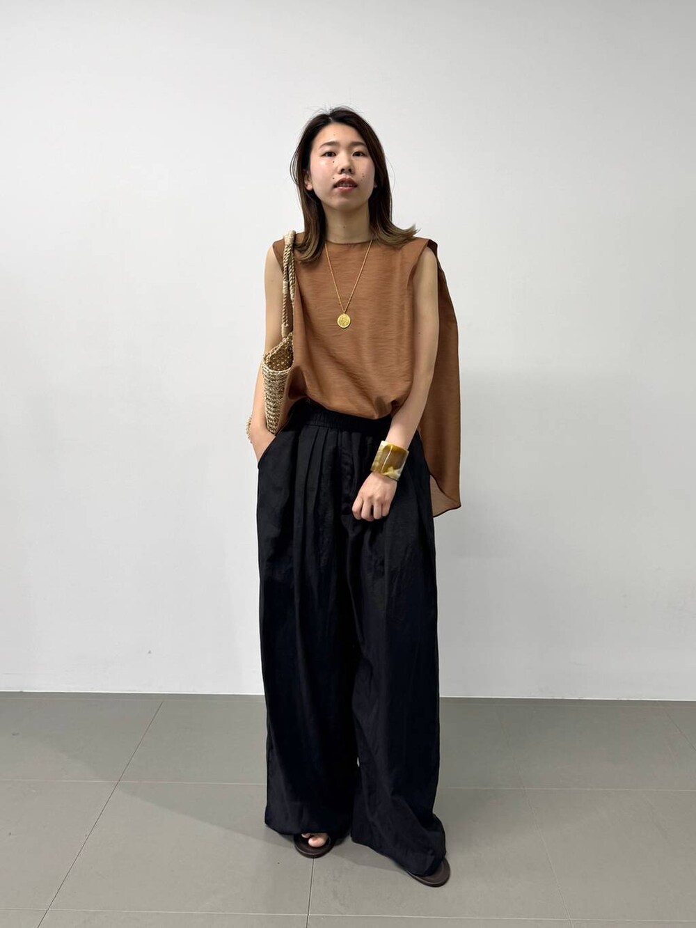 ベージュ系のかごバッグ、ブラウン系のシャツ/ブラウス、ブラック系のその他パンツを着用したレディースの夏コーディネートの4枚目の写真