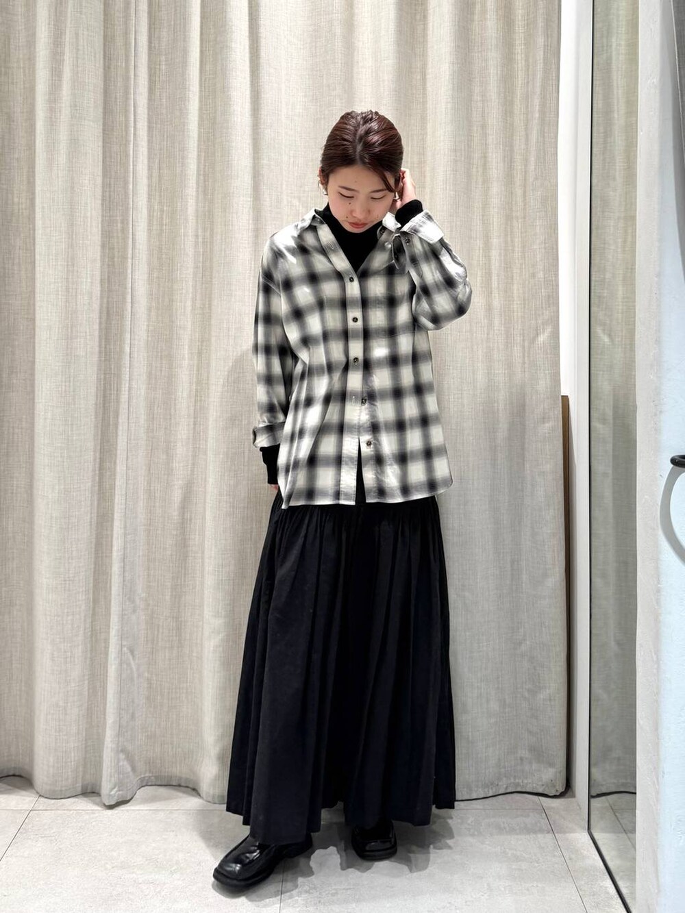 ブラック系のニット/セーター、ブラック系のシャツ/ブラウス、ブラック系のスカートを着用したレディースの冬コーディネートの3枚目の写真