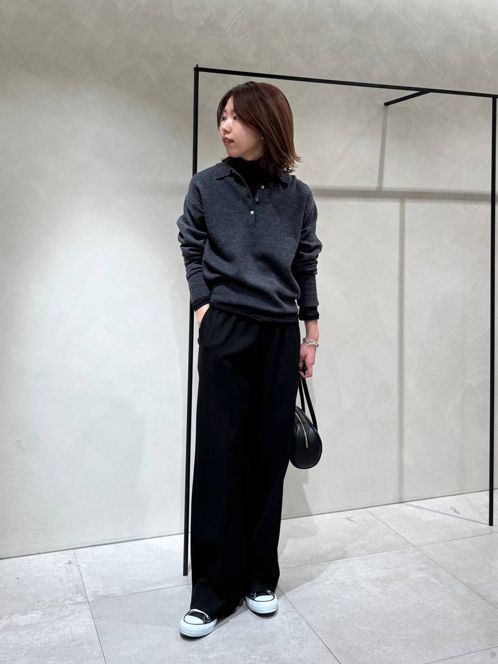 ブラック系のスニーカー、ブラック系のTシャツ/カットソー、グレー系のニット/セーターを着用したレディースの冬コーディネートの4枚目の写真