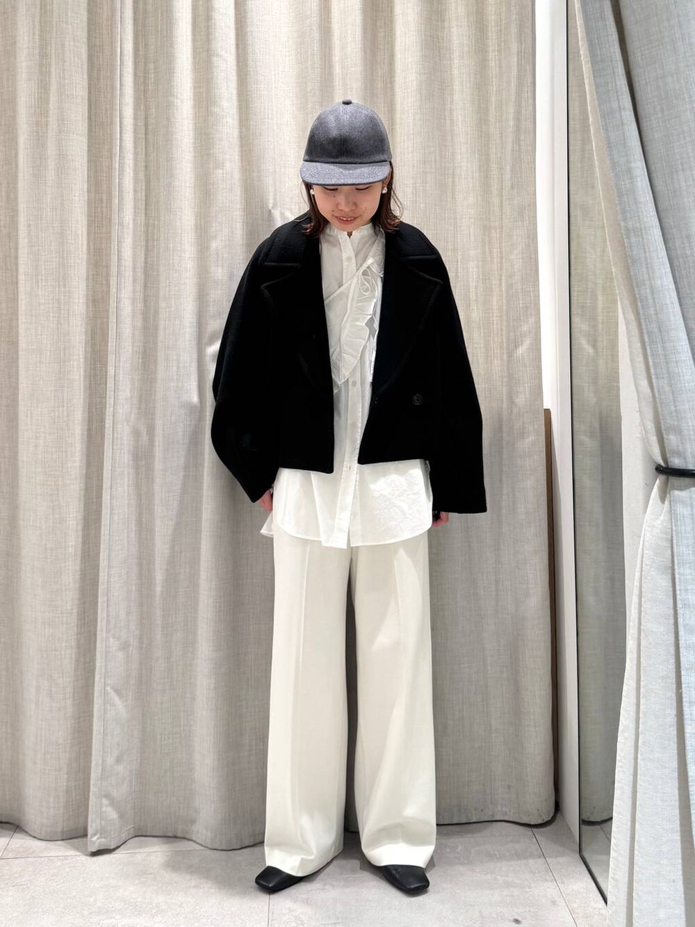 ホワイト系のその他パンツ、ホワイト系のシャツ/ブラウス、ブラック系のピーコートを着用したレディースの冬コーディネートの2枚目の写真