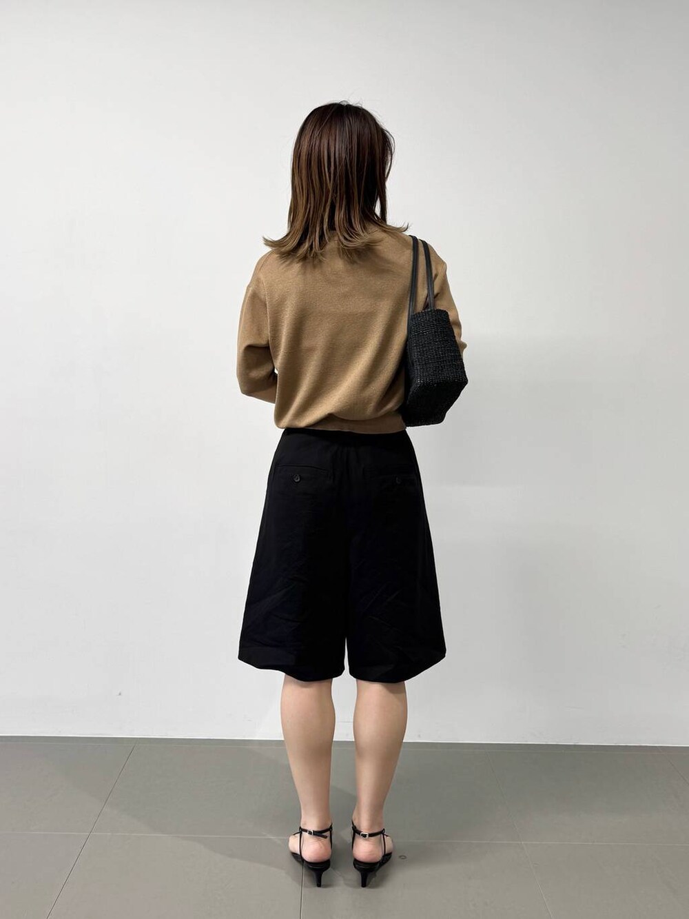 ブラック系のかごバッグ、ベージュ系のTシャツ/カットソー、ブラック系のサンダルを着用したレディースの夏コーディネートの5枚目の写真