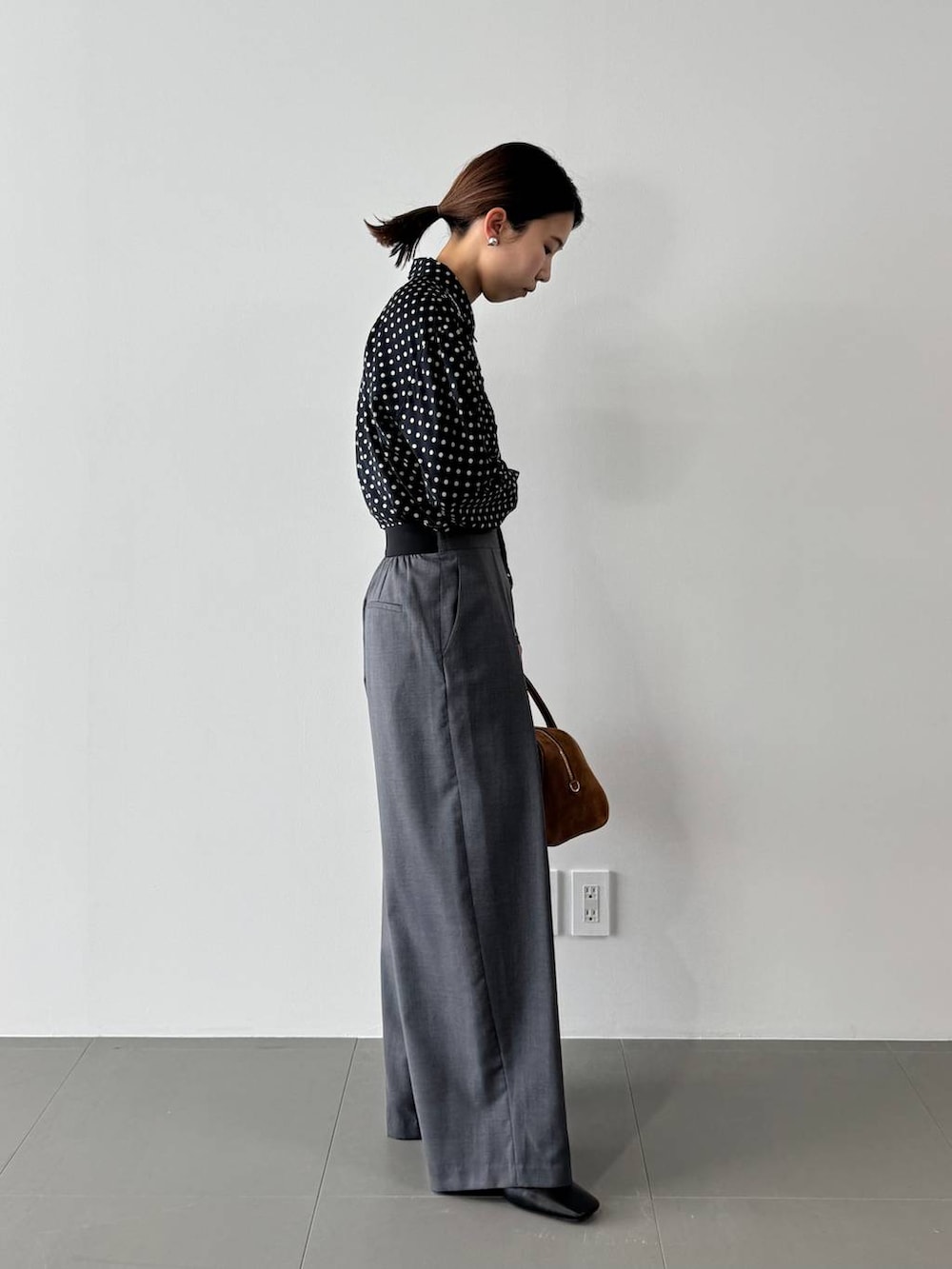 グレー系のその他パンツ、ブルー系のシャツ/ブラウス、イエロー系のボストンバッグを着用したレディースの冬コーディネートの2枚目の写真