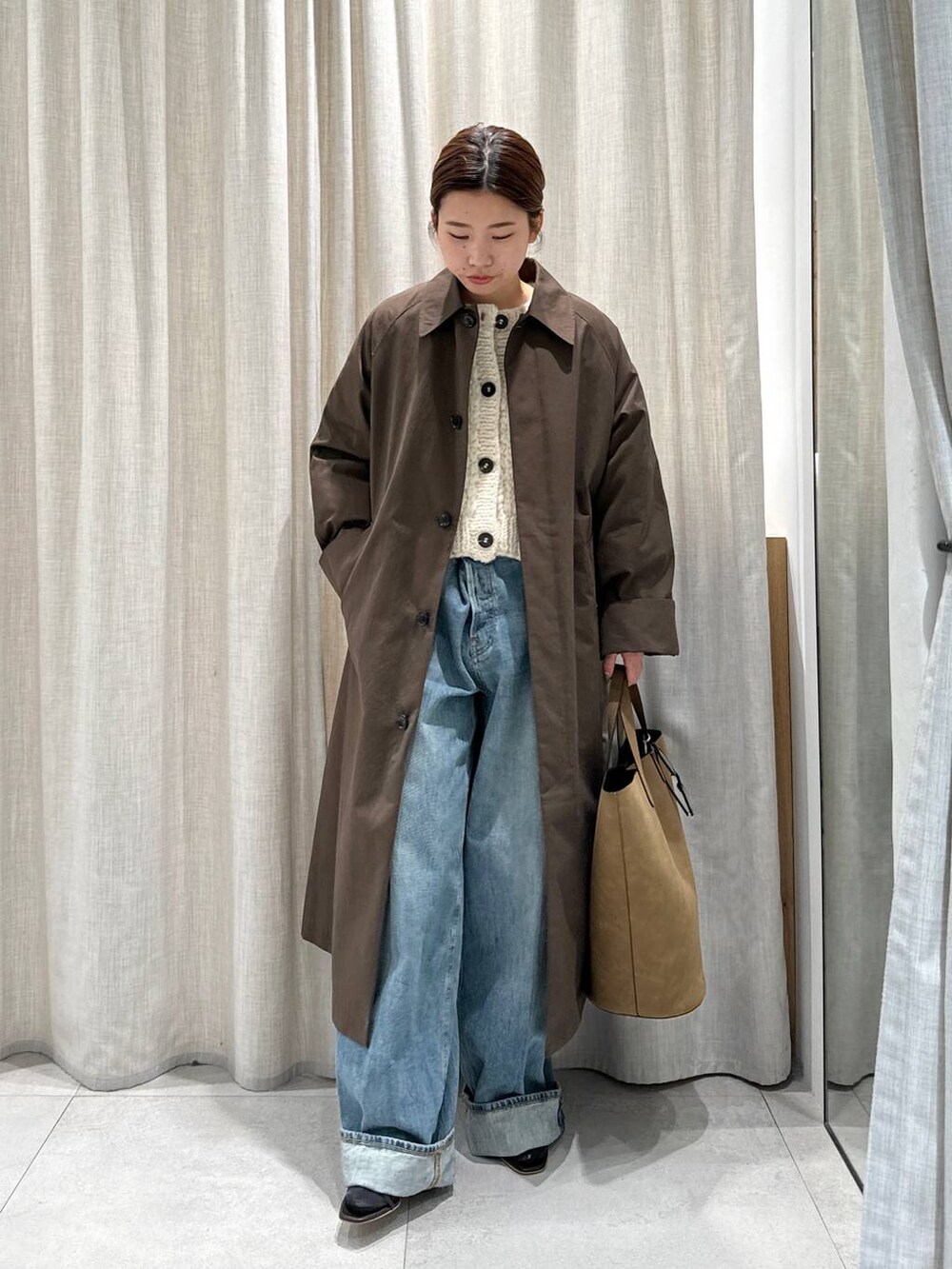 ベージュ系のカーディガン/ボレロ、ブラウン系のサンダル、ブルー系のデニムパンツを着用したレディースの秋コーディネートの6枚目の写真