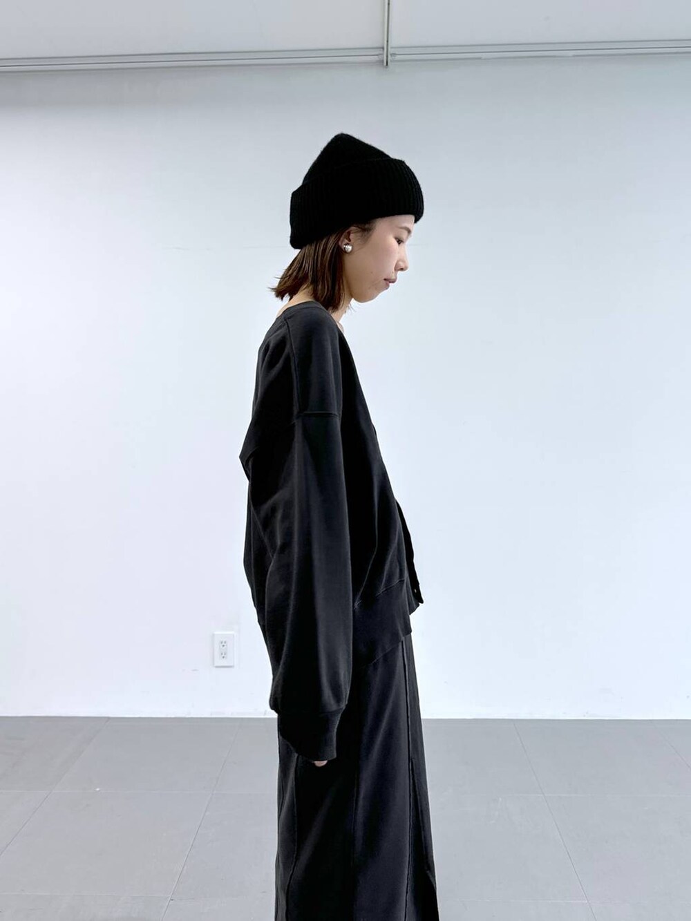 ブラック系のキャミソール、グレー系のスカート、グレー系のカーディガン/ボレロを着用したレディースの冬コーディネートの8枚目の写真