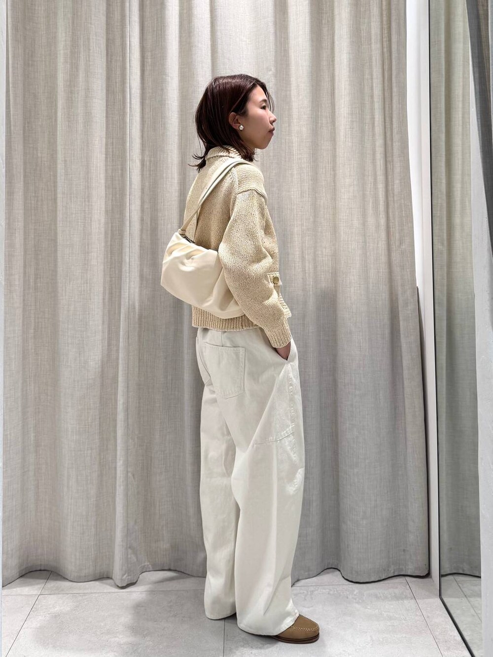 ベージュ系のショルダーバッグ、グリーン系のピーコート、ホワイト系のその他パンツを着用したレディースの冬コーディネートの9枚目の写真