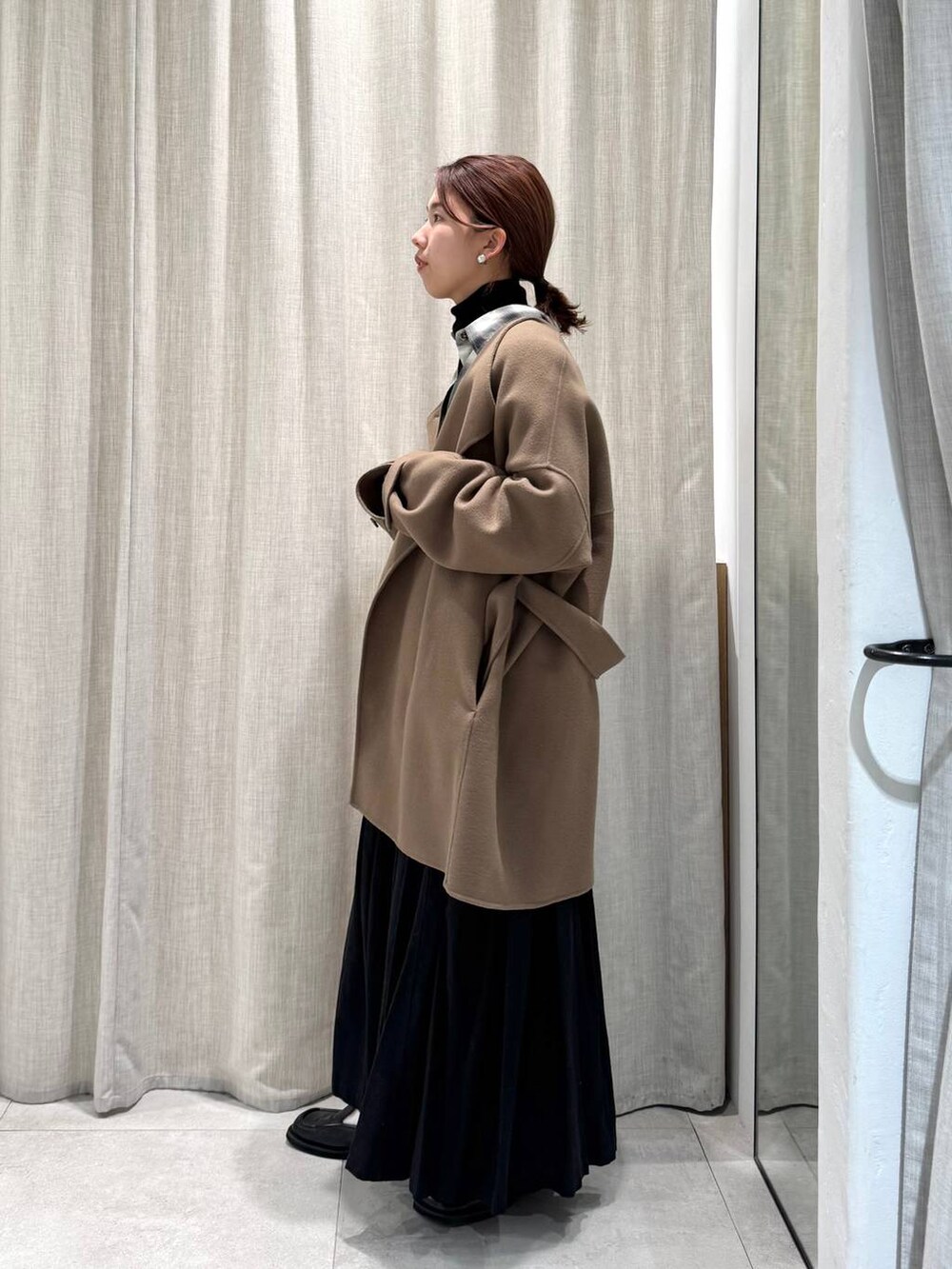 ブラック系のニット/セーター、ブラック系のシャツ/ブラウス、グリーン系のピーコートを着用したレディースの冬コーディネートの6枚目の写真