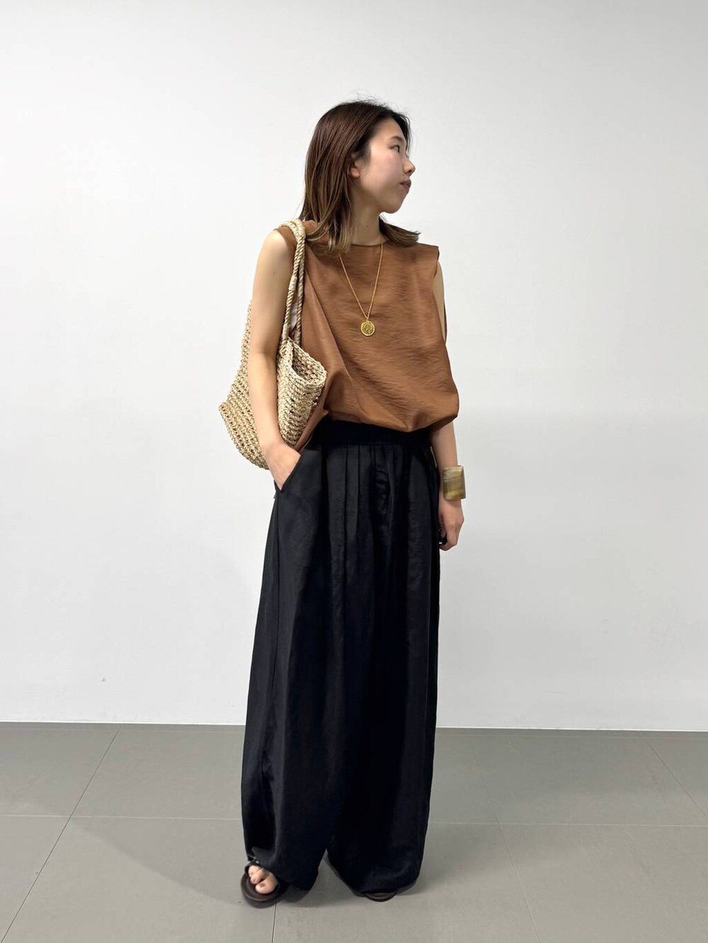 ベージュ系のかごバッグ、ブラウン系のシャツ/ブラウス、ブラック系のその他パンツを着用したレディースの夏コーディネートの3枚目の写真