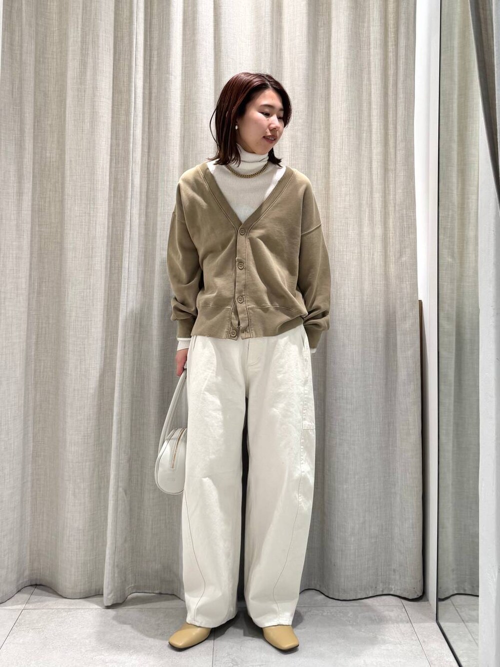 ホワイト系のニット/セーター、ホワイト系のその他パンツ、ベージュ系のカーディガン/ボレロを着用したレディースの冬コーディネートの3枚目の写真