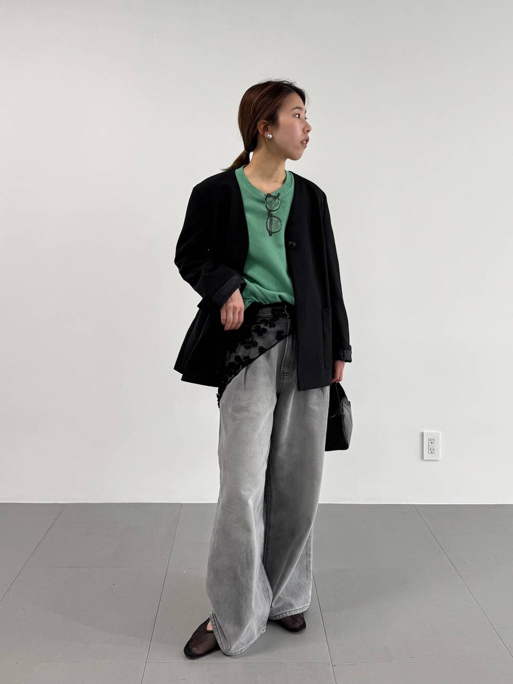 グレー系のデニムパンツ、ブラック系のパンプス、ブラック系のノーカラージャケットを着用したレディースの冬コーディネートの2枚目の写真