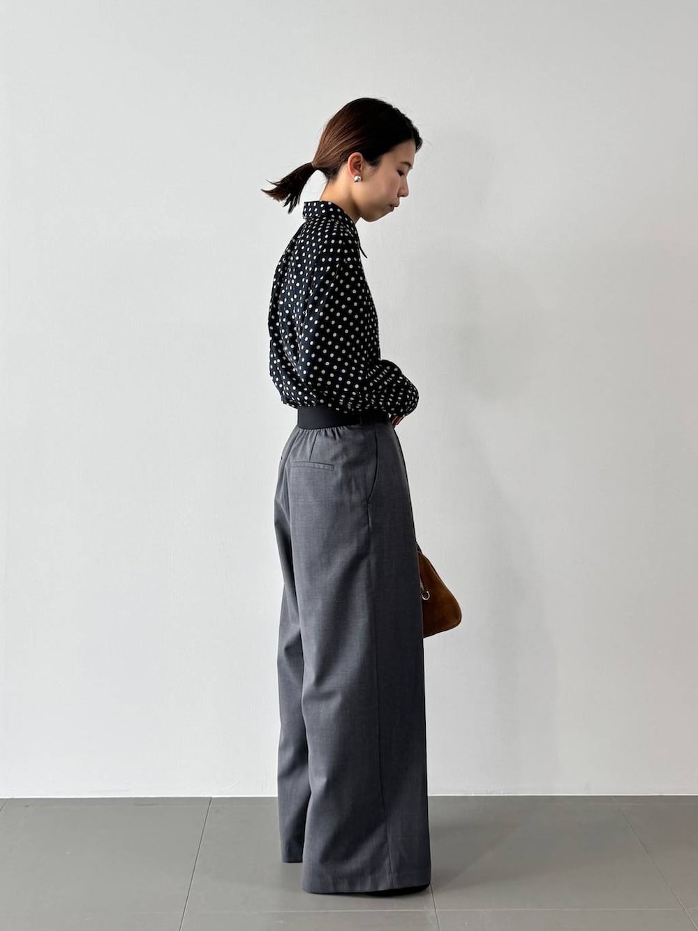 グレー系のその他パンツ、ブルー系のシャツ/ブラウス、イエロー系のボストンバッグを着用したレディースの冬コーディネートの6枚目の写真