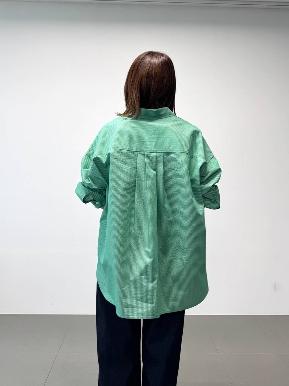 シルバー系のパンプス、グリーン系のシャツ/ブラウス、ホワイト系のTシャツ/カットソーを着用したレディースの夏コーディネートの9枚目の写真