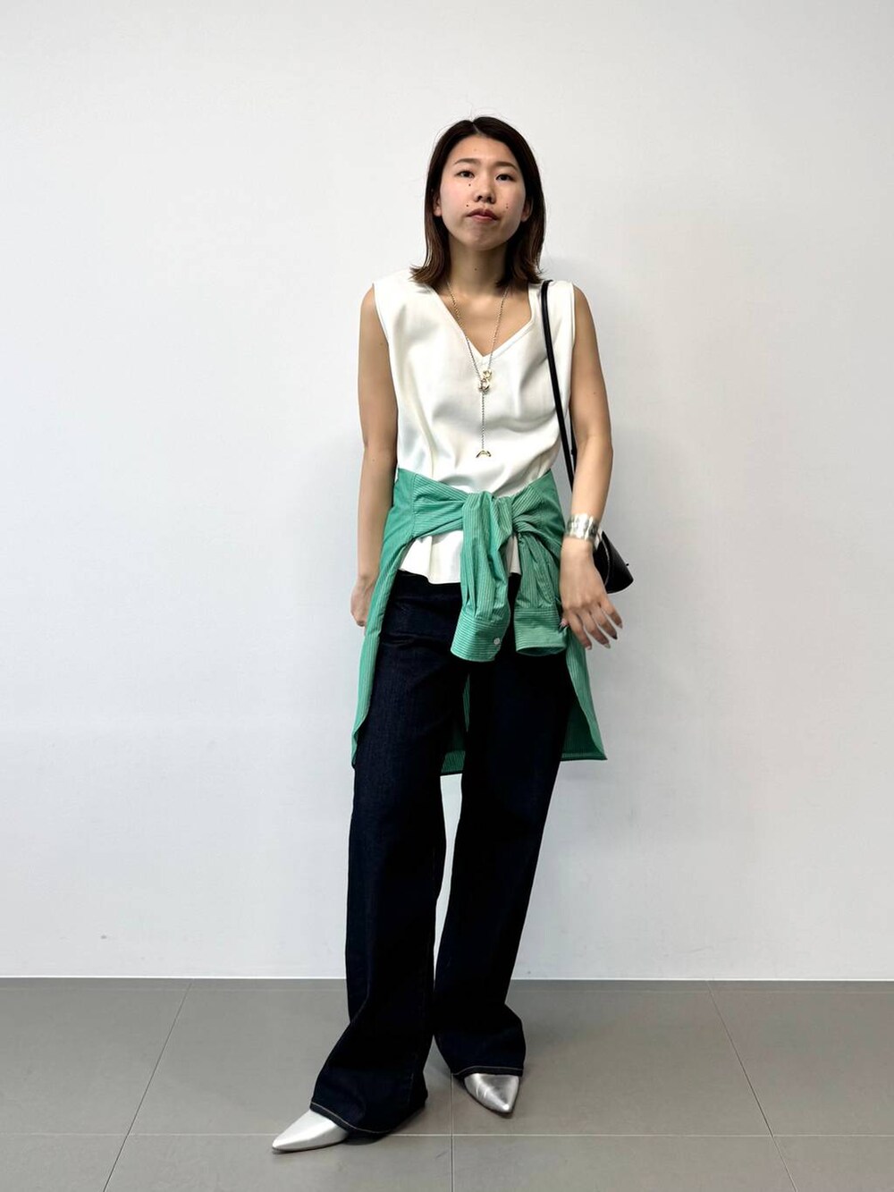 シルバー系のパンプス、グリーン系のシャツ/ブラウス、ホワイト系のTシャツ/カットソーを着用したレディースの夏コーディネートの3枚目の写真