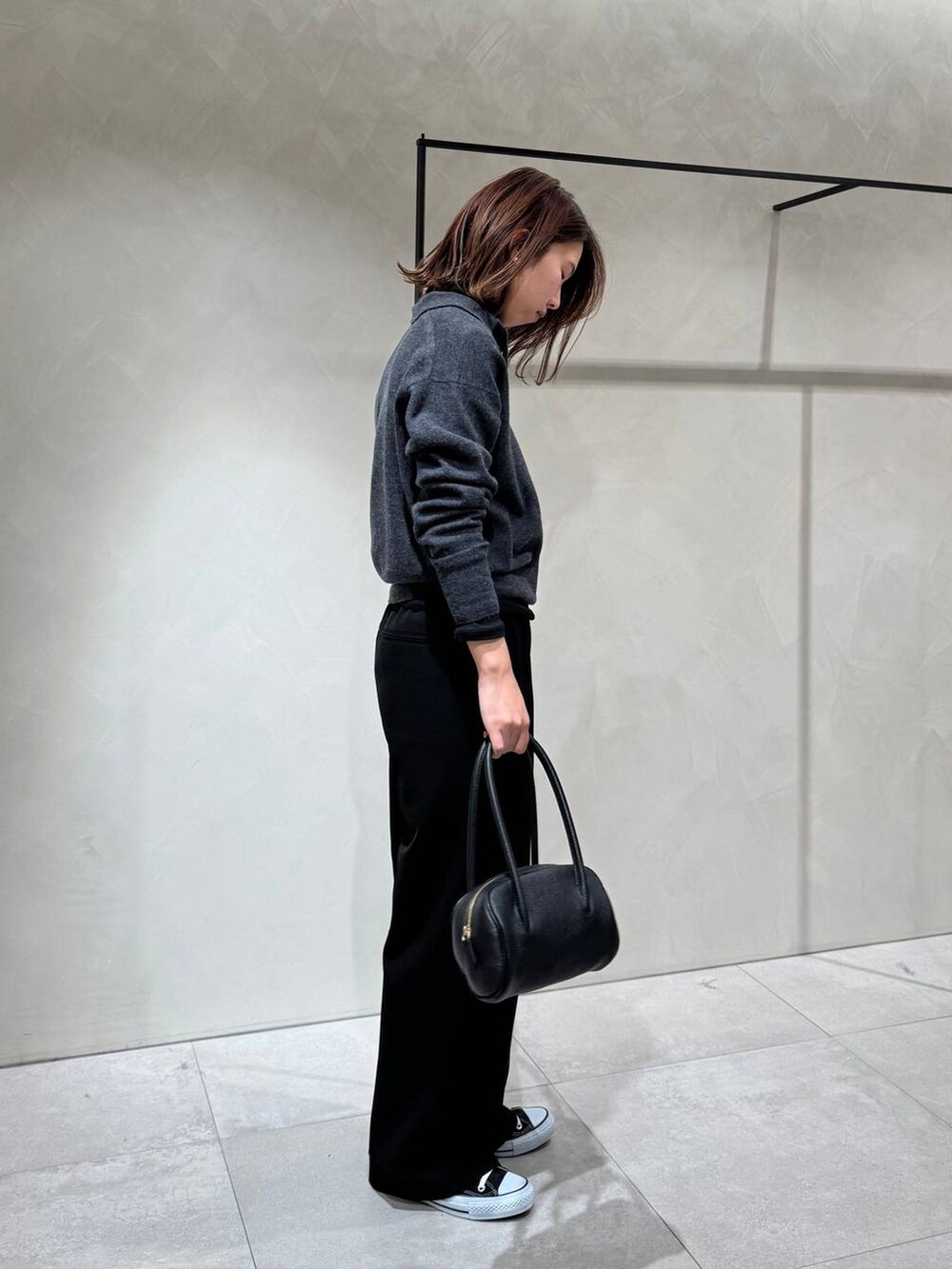 ブラック系のスニーカー、ブラック系のTシャツ/カットソー、グレー系のニット/セーターを着用したレディースの冬コーディネートの5枚目の写真
