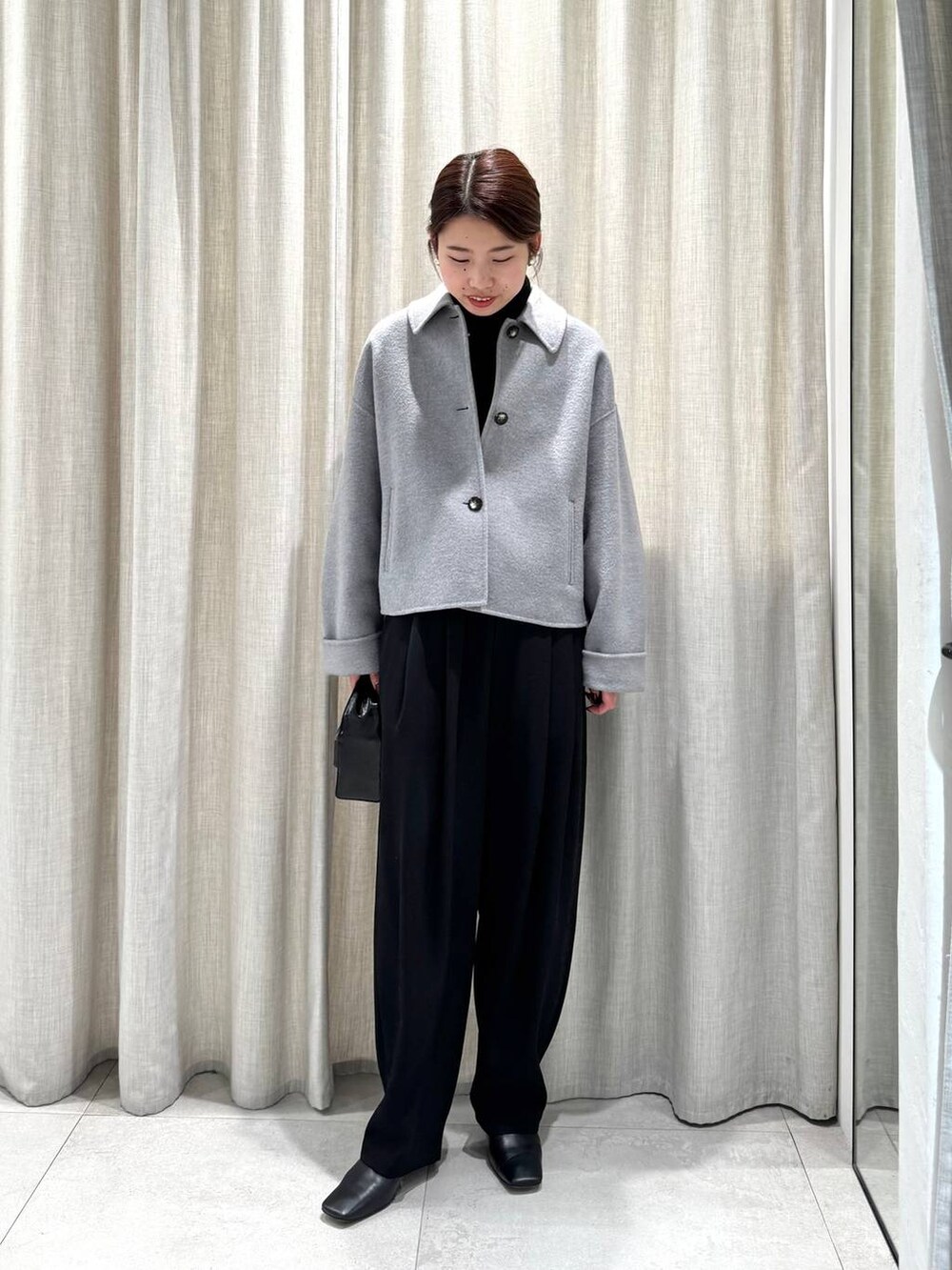 ブラック系のその他パンツ、ブラック系のニット/セーター、グレー系のその他アウターを着用したレディースの冬コーディネートの5枚目の写真