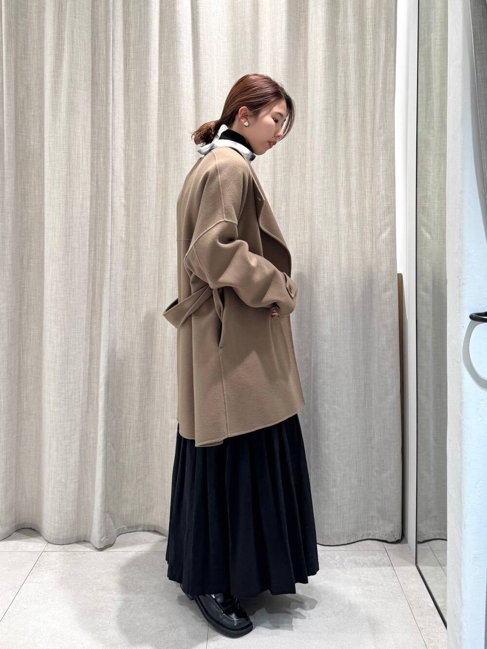 ブラック系のニット/セーター、ブラック系のシャツ/ブラウス、グリーン系のピーコートを着用したレディースの冬コーディネートの4枚目の写真