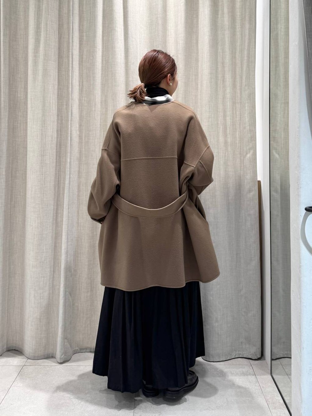 ブラック系のニット/セーター、ブラック系のシャツ/ブラウス、グリーン系のピーコートを着用したレディースの冬コーディネートの5枚目の写真