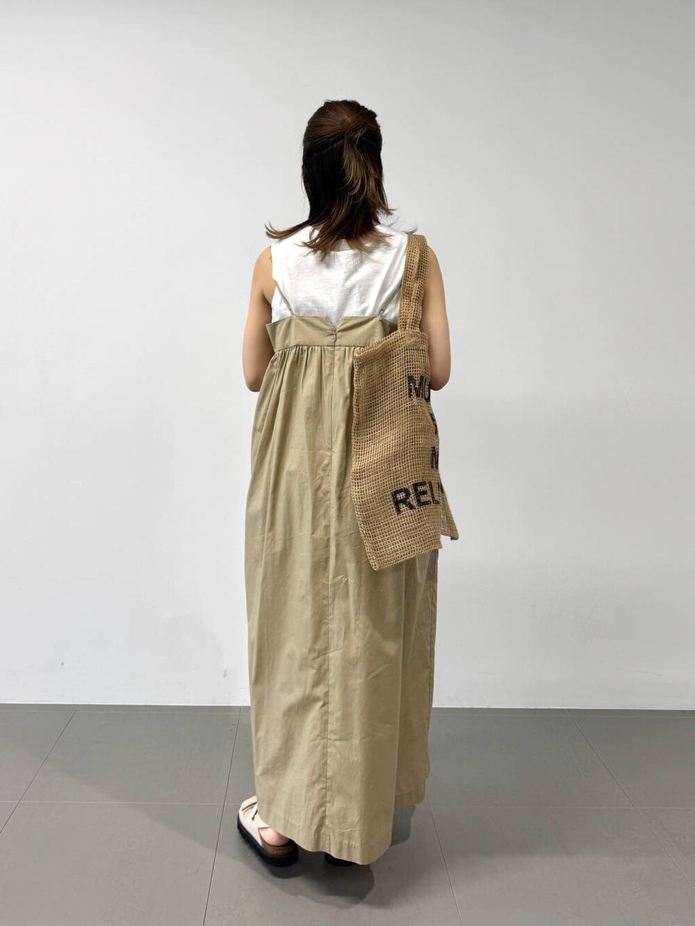 ベージュ系のトートバッグ、ホワイト系のタンクトップ、ベージュ系のワンピースを着用したレディースの夏コーディネートの7枚目の写真