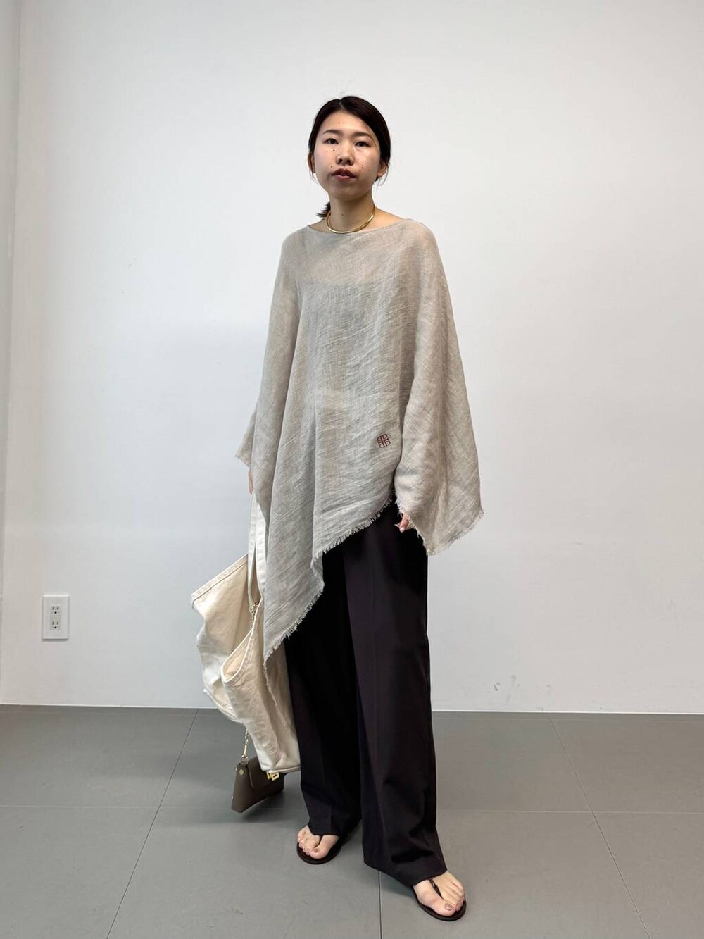 ブラウン系のサンダル、ホワイト系のトートバッグ、ベージュ系のその他トップスを着用したレディースの夏コーディネートの5枚目の写真