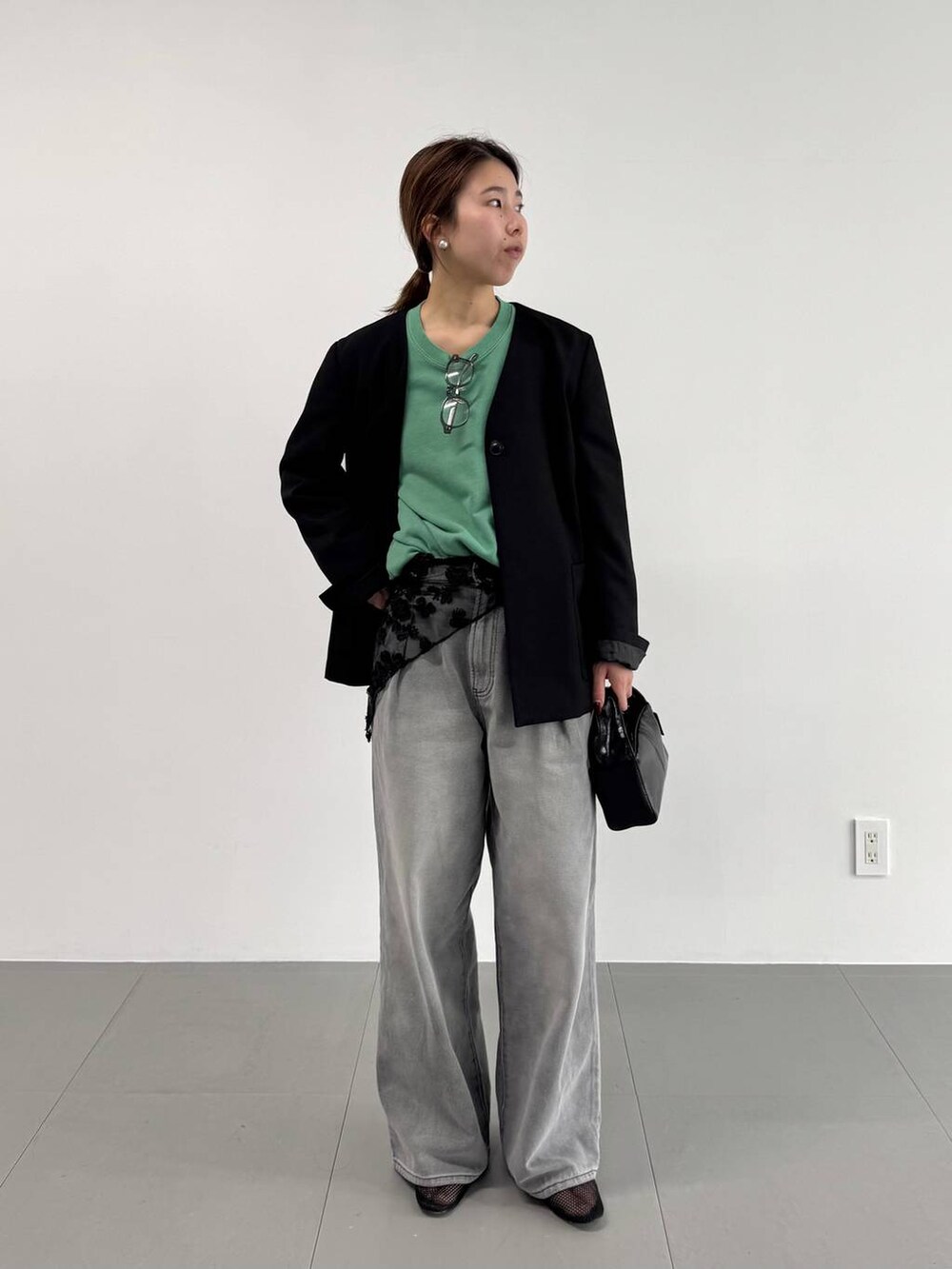 グレー系のデニムパンツ、ブラック系のパンプス、ブラック系のノーカラージャケットを着用したレディースの冬コーディネートの3枚目の写真