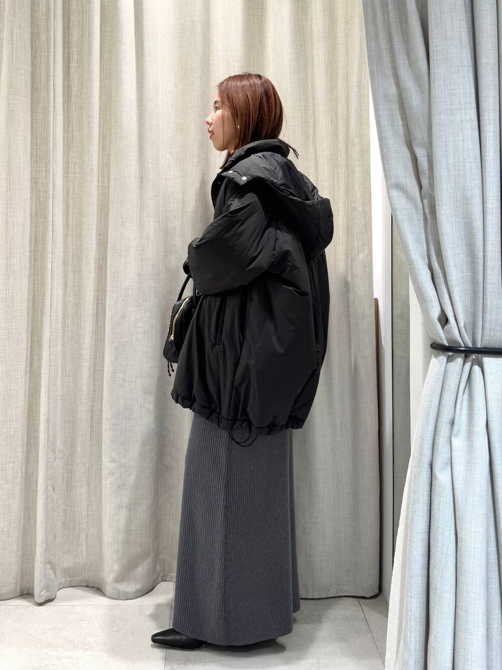 グレー系のブルゾン、ブルー系のTシャツ/カットソー、グレー系のスカートを着用したレディースの冬コーディネートの7枚目の写真