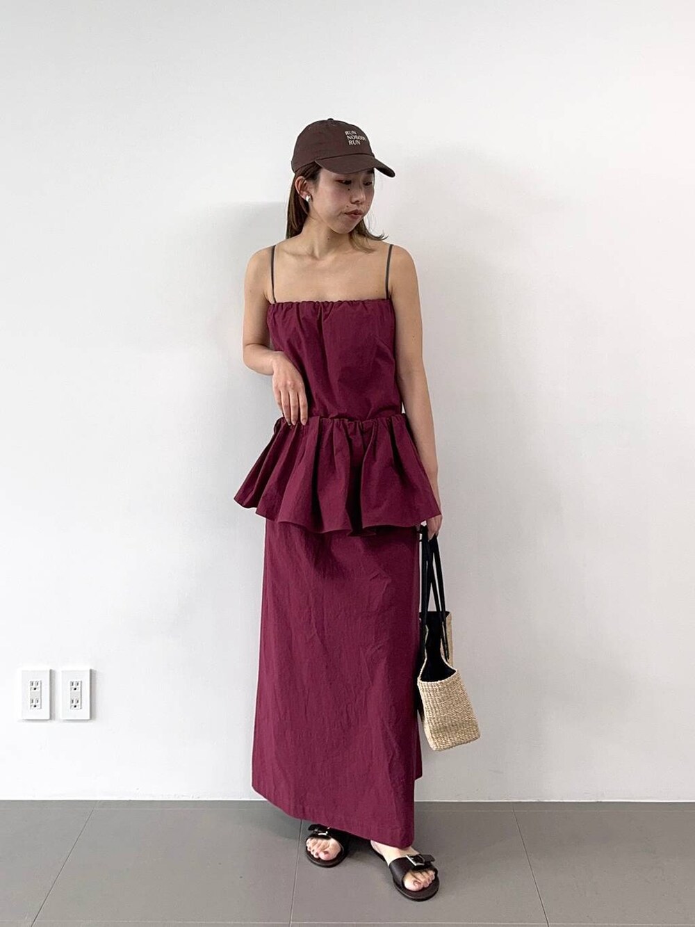 ベージュ系のかごバッグ、レッド系のワンピース、ブラウン系のキャップを着用したレディースの春コーディネートの7枚目の写真