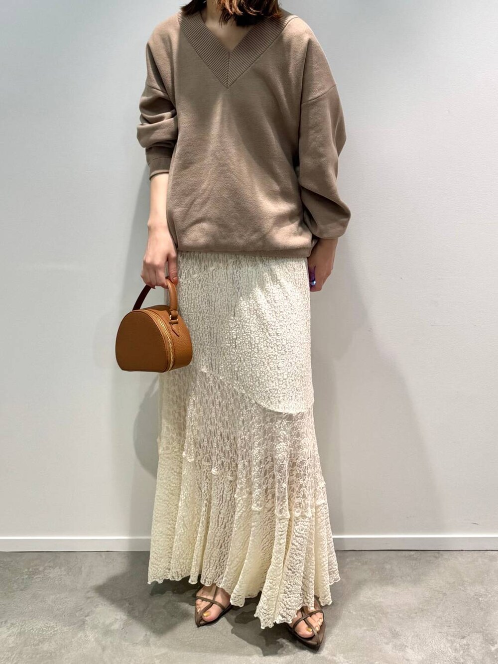 ベージュ系のサンダル、ホワイト系のスカート、イエロー系のハンドバッグを着用したレディースの夏コーディネートの6枚目の写真