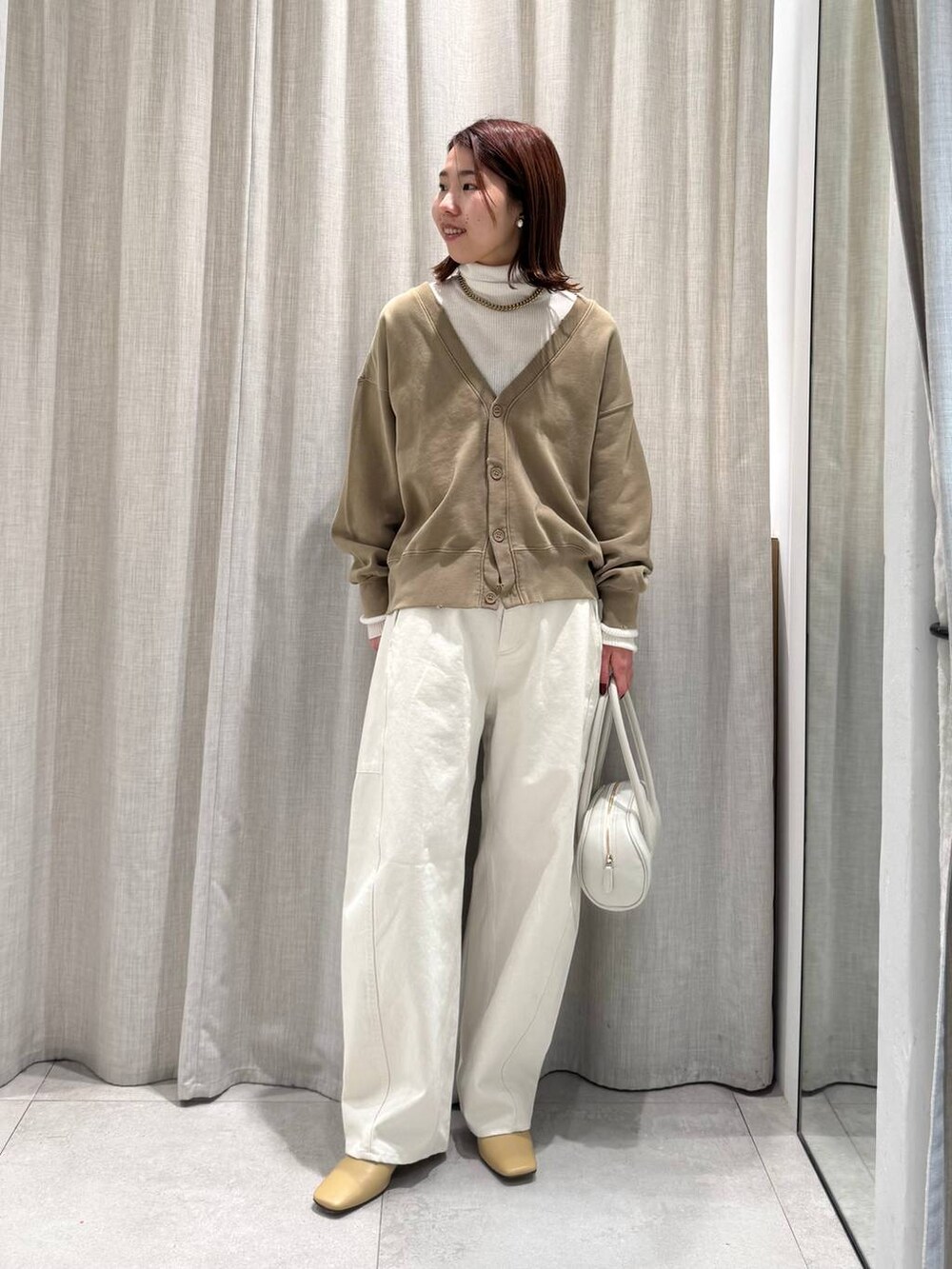 ホワイト系のニット/セーター、ホワイト系のその他パンツ、ベージュ系のカーディガン/ボレロを着用したレディースの冬コーディネートの4枚目の写真