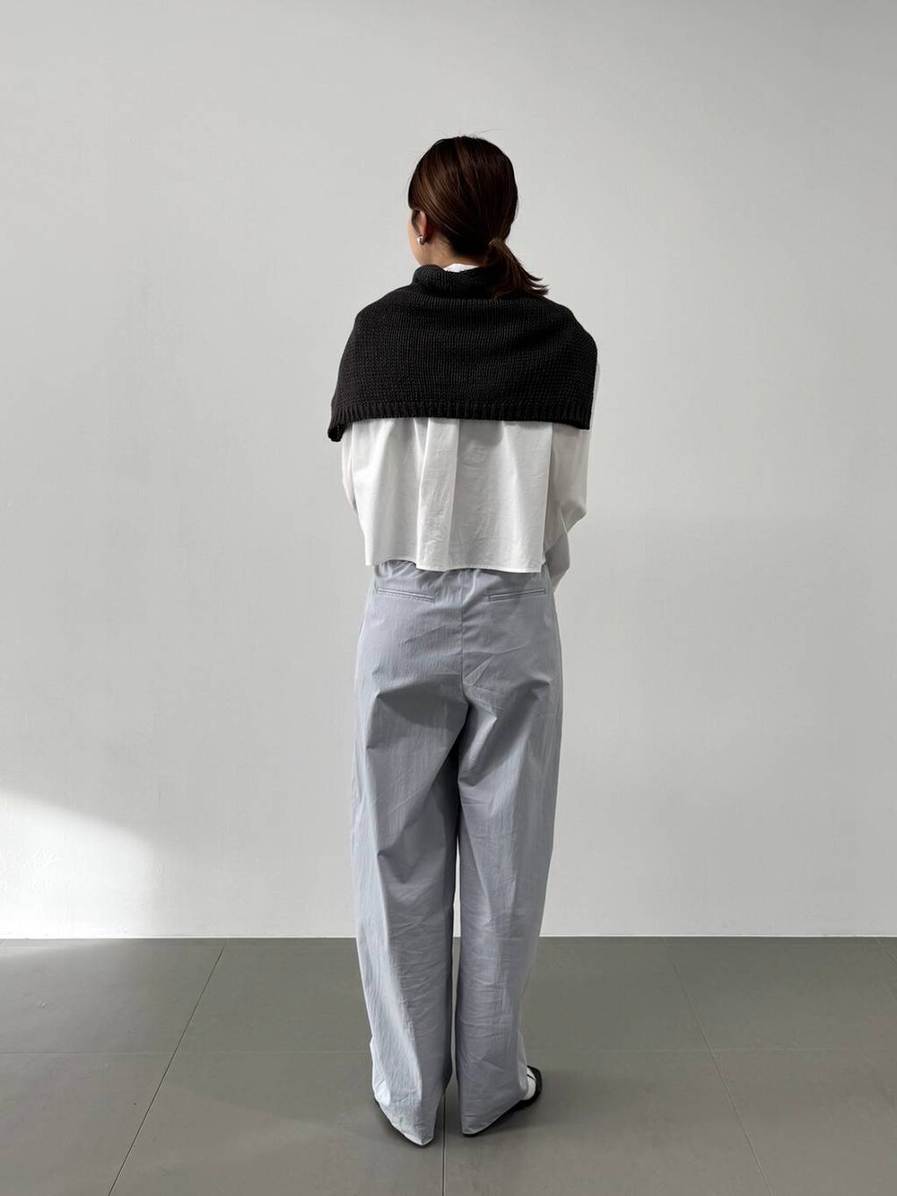 ホワイト系のハンドバッグ、ホワイト系のシャツ/ブラウス、ブラック系のサンダルを着用したレディースの冬コーディネートの6枚目の写真