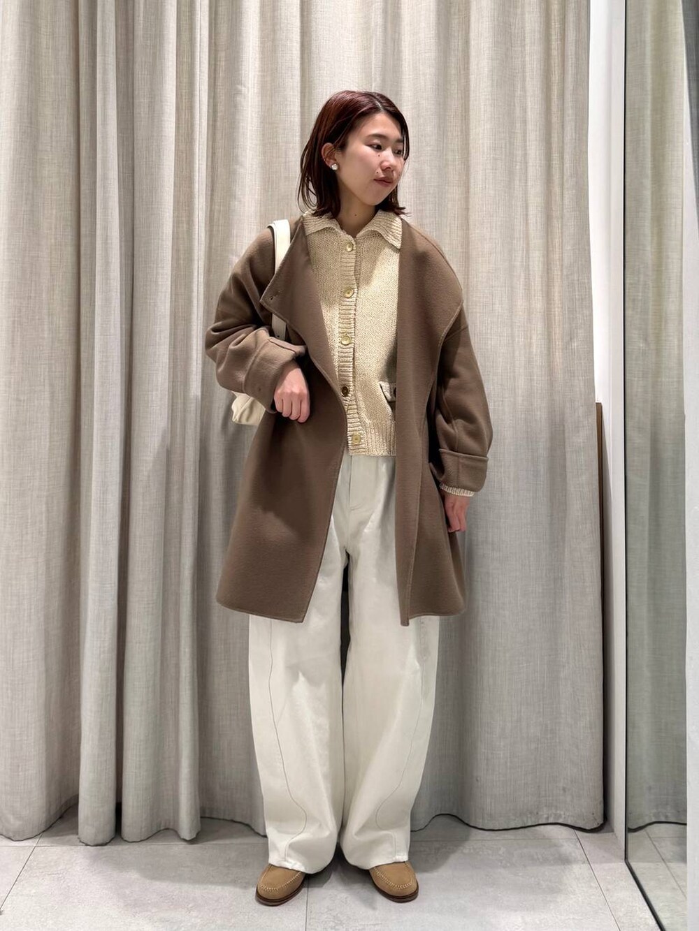 ベージュ系のショルダーバッグ、グリーン系のピーコート、ホワイト系のその他パンツを着用したレディースの冬コーディネートの4枚目の写真