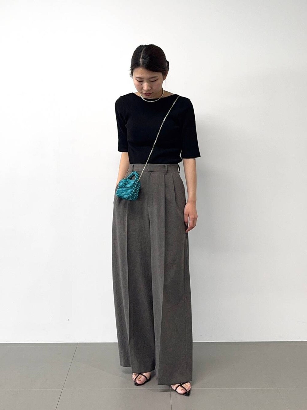 ブラック系のサンダル、ブラック系のTシャツ/カットソー、グレー系のその他パンツを着用したレディースの春コーディネートの3枚目の写真