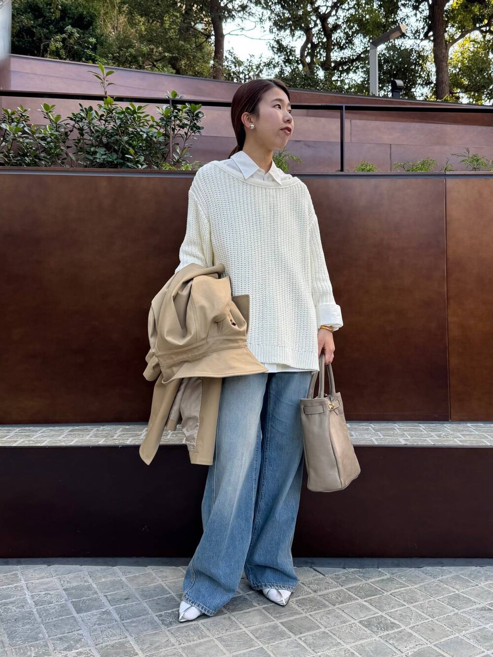 ブルー系のデニムパンツ、ホワイト系のニット/セーター、ホワイト系のシャツ/ブラウスを着用したレディースの春コーディネートの3枚目の写真