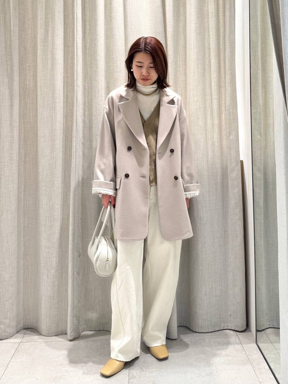 ホワイト系のニット/セーター、ベージュ系のテーラードジャケット、ベージュ系のカーディガン/ボレロを着用したレディースの冬コーディネートの4枚目の写真