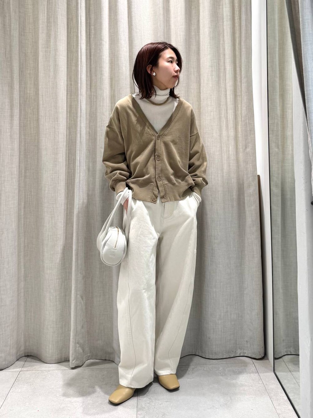 ホワイト系のニット/セーター、ホワイト系のその他パンツ、ベージュ系のカーディガン/ボレロを着用したレディースの冬コーディネートの2枚目の写真