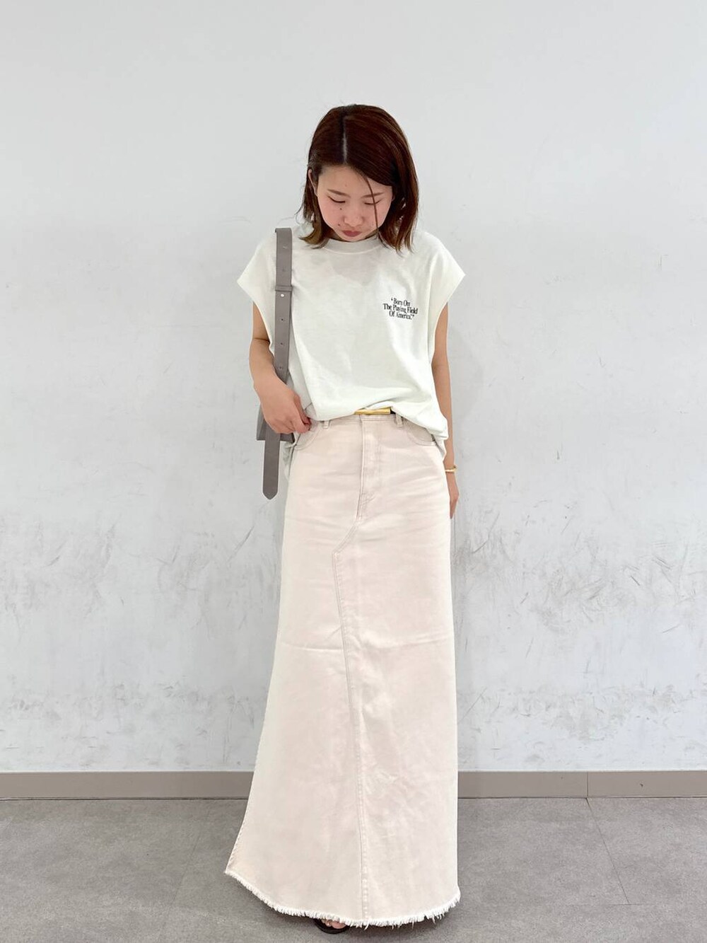 ブラウン系のサンダル、ホワイト系のTシャツ/カットソー、グリーン系のショルダーバッグを着用したレディースの夏コーディネートの4枚目の写真