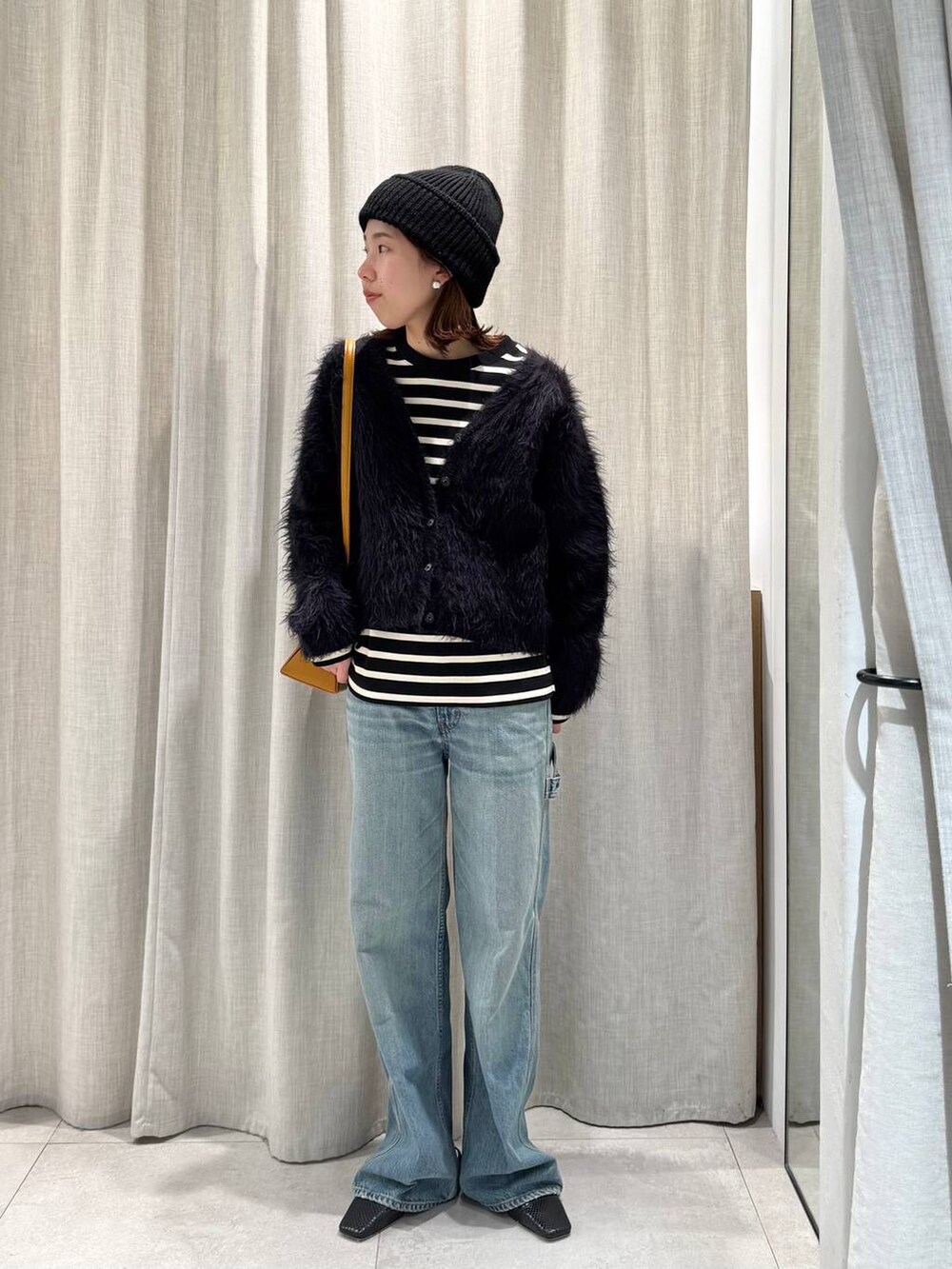 ブラック系のTシャツ/カットソー、ブルー系のカーディガン/ボレロ、ブルー系のデニムパンツを着用したレディースの冬コーディネートの4枚目の写真