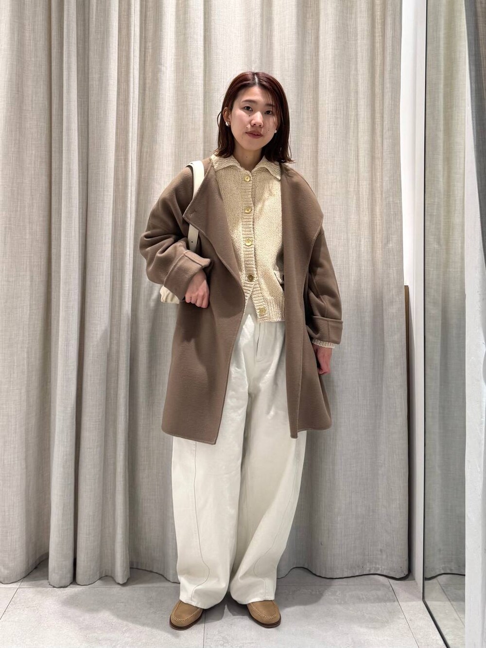 ベージュ系のショルダーバッグ、グリーン系のピーコート、ホワイト系のその他パンツを着用したレディースの冬コーディネートの5枚目の写真